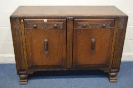 AN ART DECO CARVED OAK SIDEBOARD with two drawers, width 136cm x depth 50cm x height 92cm (missing