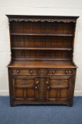 A GOOD QUALITY REPRODUCTION CARVED OAK DRESSER, double plate rack top, above a base with two drawers