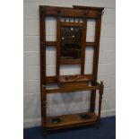 AN EDWARDIAN WALNUT HALL STAND, with six hooks but one hook missing, central bevelled mirror, hinged