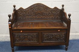 A REPRODUCTION CARVED HARDWOOD HALL SETTLE, with a hinged storage compartment, width 100cm x depth