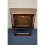 AN REPRODUCTION CARVED OAK SINGLE DOOR CREDENCE CABINET, with canted corners, on turned supports