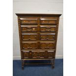 A REPRODUCTION OAK GEOMETRIC CHEST ON STAND, with two short and four long drawers, on barley twist