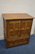 A REPRODUCTION PANELLED OAK TV CABINET with the year 1987 caved to the frieze, and two door that