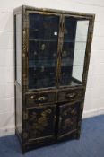AN EBONISED AND CHINOISERIE GILT PAINTED TWO DOOR DISPLAY CABINET, with two glass shelves, lighting,