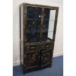 AN EBONISED AND CHINOISERIE GILT PAINTED TWO DOOR DISPLAY CABINET, with two glass shelves, lighting,