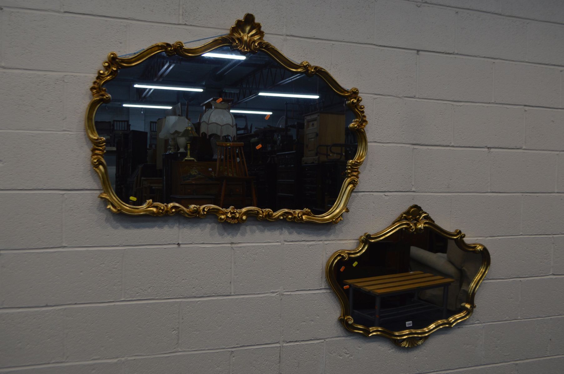 A MODERN ORNATE GILT ON RESIN WALL MIRROR, width 122cm x 88cm, together with a similar wall