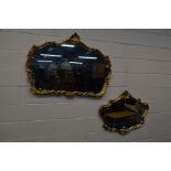 A MODERN ORNATE GILT ON RESIN WALL MIRROR, width 122cm x 88cm, together with a similar wall