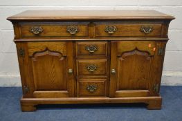 A REPRODUCTION OAK SIDEBOARD, Taylor and Co of England label attached, with five assorted drawers