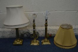 A PAIR OF BRASS CORNITHIAN TABLE LAMPS with gold fabric shades, and another brass table lamp with