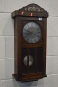 AN EARLY 20TH CENTURY OAK WALL CLOCK (winding key)