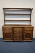 A GEORGIAN OAK AND MAHOGANY BREAKFRONT DRESSER, later plate rack top, the base with three drawers,