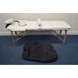 A CREAM FOLDING THERAPY BED with various accessories and bag