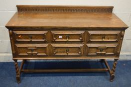 A REPRODUCTION OAK GEOMETRIC SIDEBOARD/CHEST OF TWO SHORT AND TWO LONG DRAWERS, with a carved