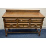 A REPRODUCTION OAK GEOMETRIC SIDEBOARD/CHEST OF TWO SHORT AND TWO LONG DRAWERS, with a carved