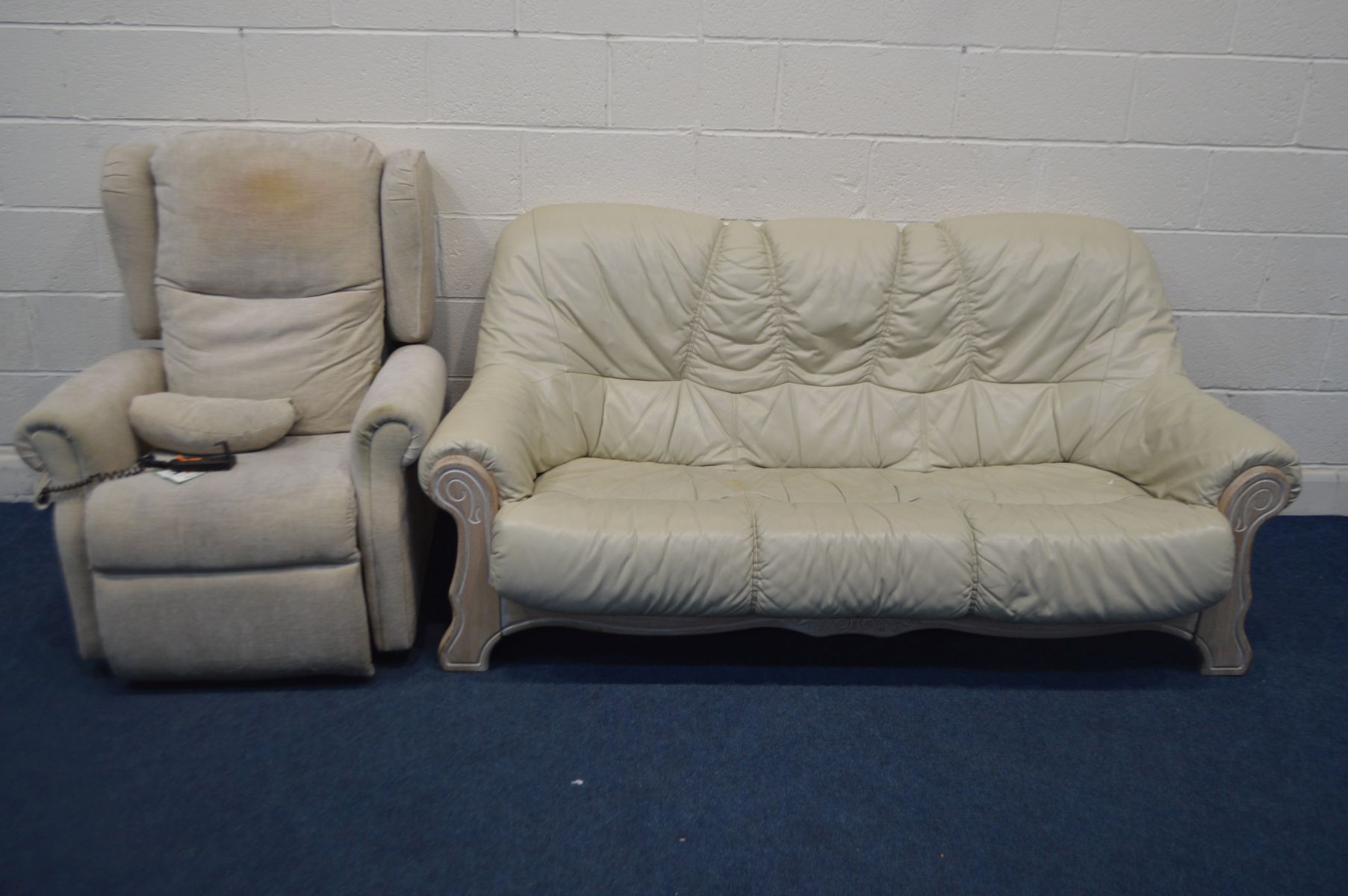 A CREAM LEATHER AND WOODEN FRAMED THREE SEATER SETTEE, and an electric rise and recline armchair (Sd