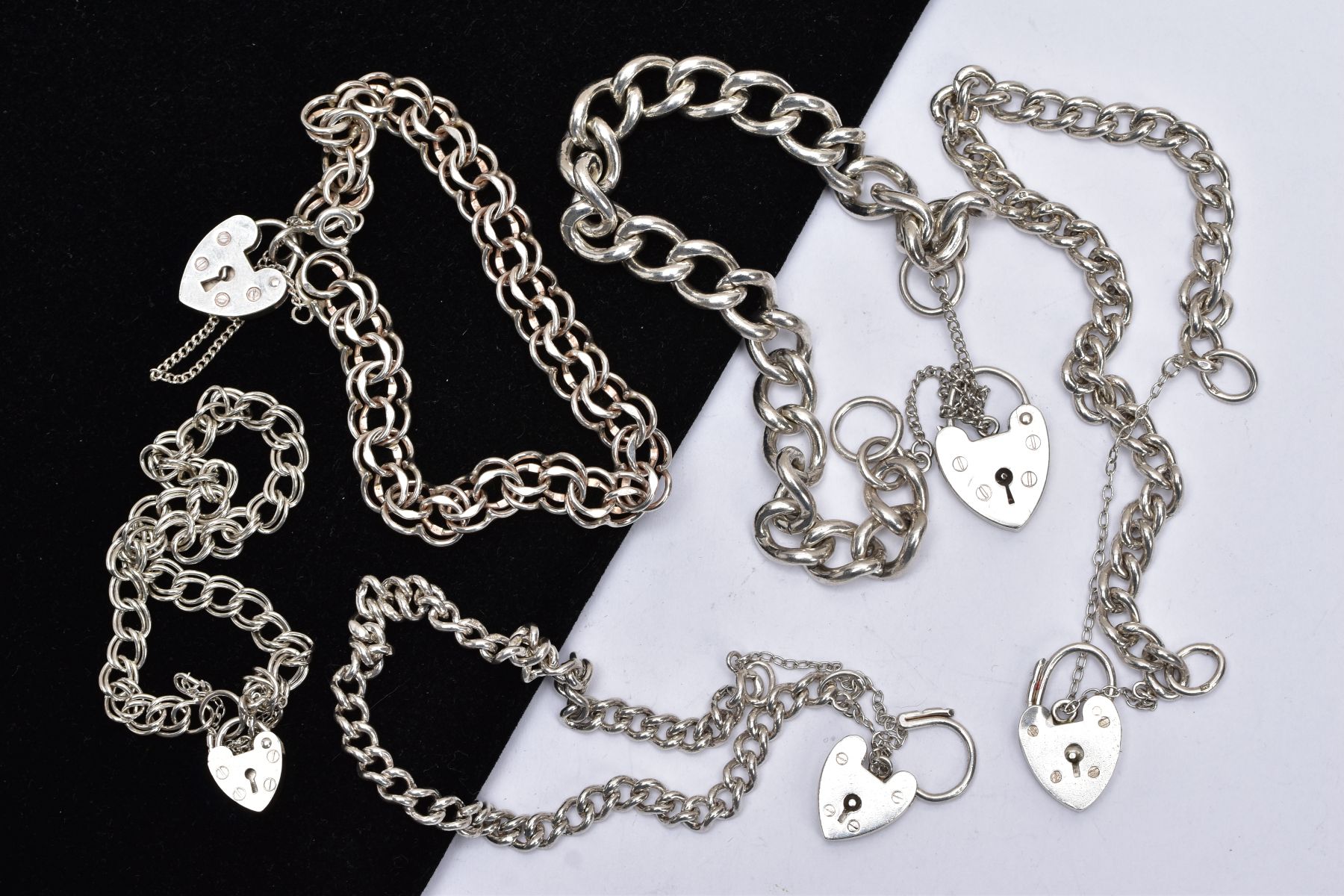 A BAG OF ASSORTED SILVER AND WHITE METAL CHARM BRACELETS, to include three curb link bracelets and