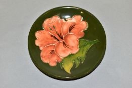 A MOORCROFT CIRCULAR CORAL HIBISCUS PATTERN PIN DISH, on a green ground, impressed marks, diameter