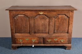 A GEORGE III OAK MULE CHEST, two plank hinged top above three fielded panels, two short drawers