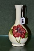A MOORCROFT ONION SHAPED VASE, the cream ground decorated with a red/blue hibiscus, green painted