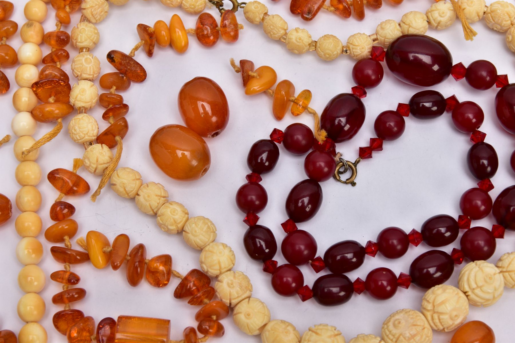 A TRAY OF AMBER AND CARVED IVORY BEAD NECKLACES AND A BROOCH, to include rough amber bead necklace - Image 2 of 6