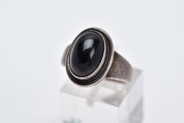 A GEORG JENSON ONYX RING, designed with a central oval onyx cabochon within a collet mount, plain