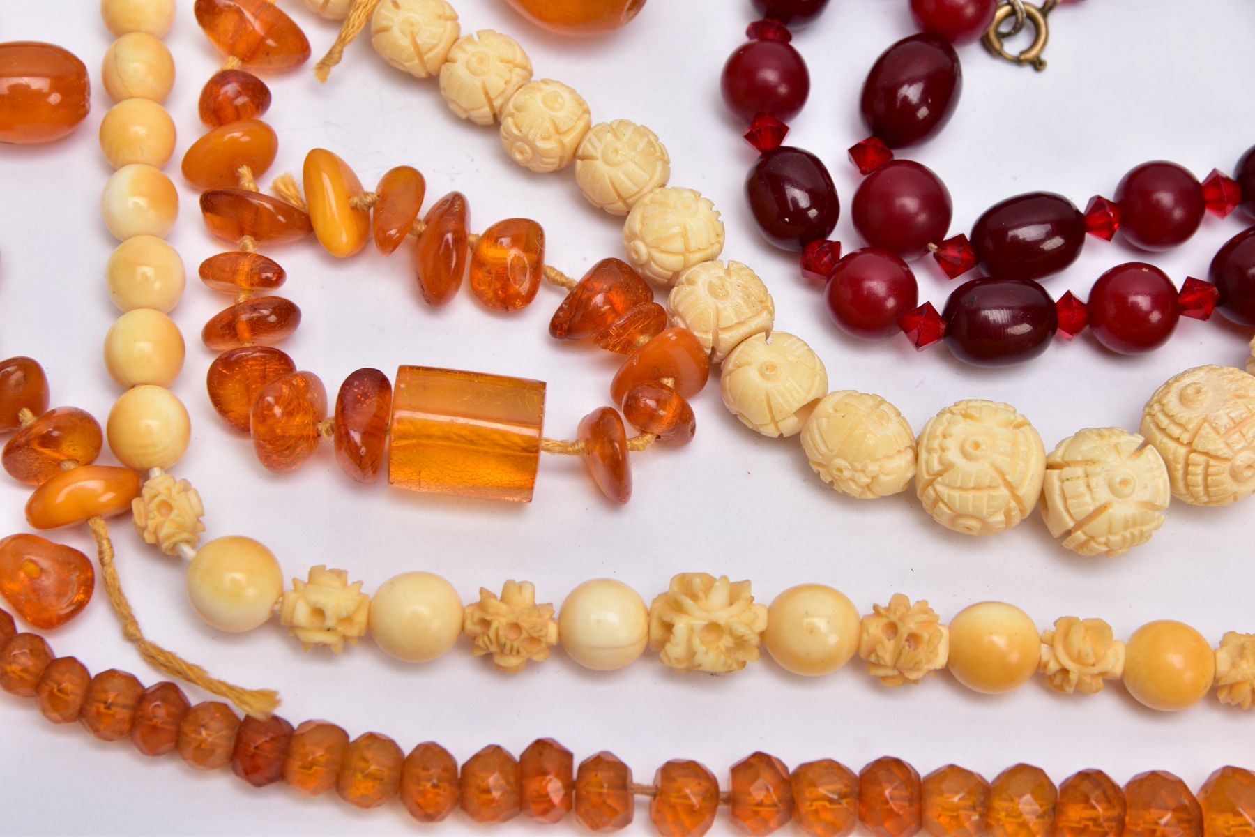 A TRAY OF AMBER AND CARVED IVORY BEAD NECKLACES AND A BROOCH, to include rough amber bead necklace - Image 6 of 6