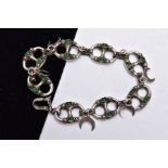 A WHITE METAL BRACELET, designed with eight oval shaped, openwork links, set with green stone