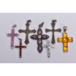 SEVEN WHITE METAL CROSS PENDANTS, to include a pink sapphire and colourless spinel set pendant (