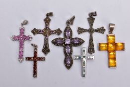 SEVEN WHITE METAL CROSS PENDANTS, to include a pink sapphire and colourless spinel set pendant (