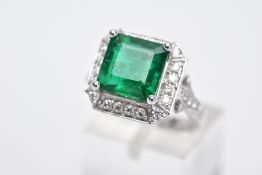 A STUNNING 18CT GOLD EMERALD AND DIAMOND CLUSTER RING, centring on a square cut emerald