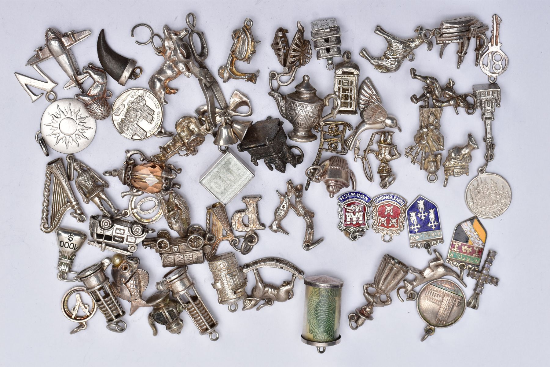 A QUANTITY OF SILVER AND WHITE METAL CHARMS, to include fifty six charms in various forms such as