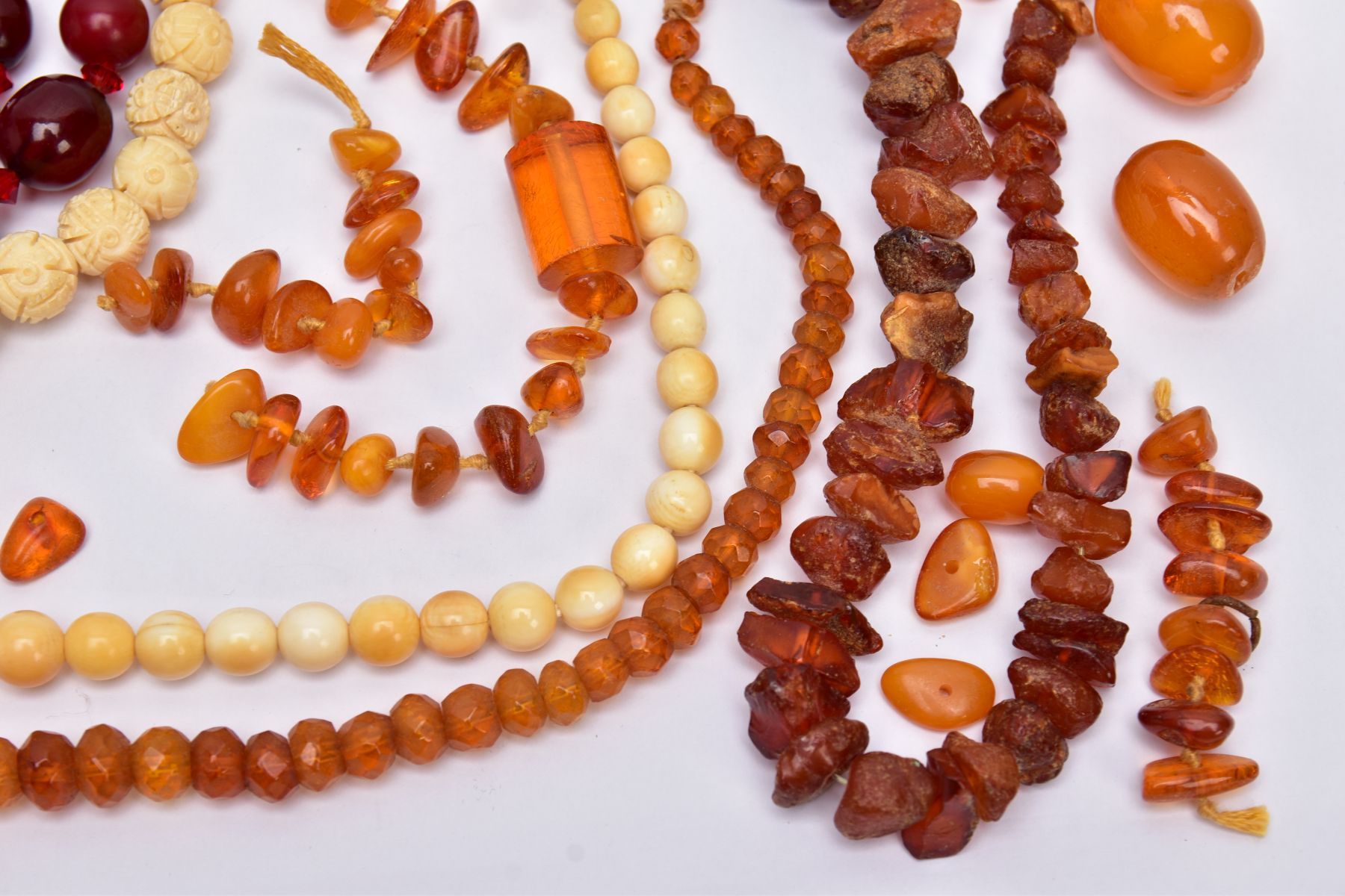 A TRAY OF AMBER AND CARVED IVORY BEAD NECKLACES AND A BROOCH, to include rough amber bead necklace - Image 3 of 6