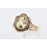 A 9CT GOLD CITRINE RING, designed with a central oval cut citrine within a collet mount, rope