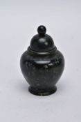 A CARVED GREEN HARDSTONE JAR, of an urn form, ball finial, on a circular base, approximate height