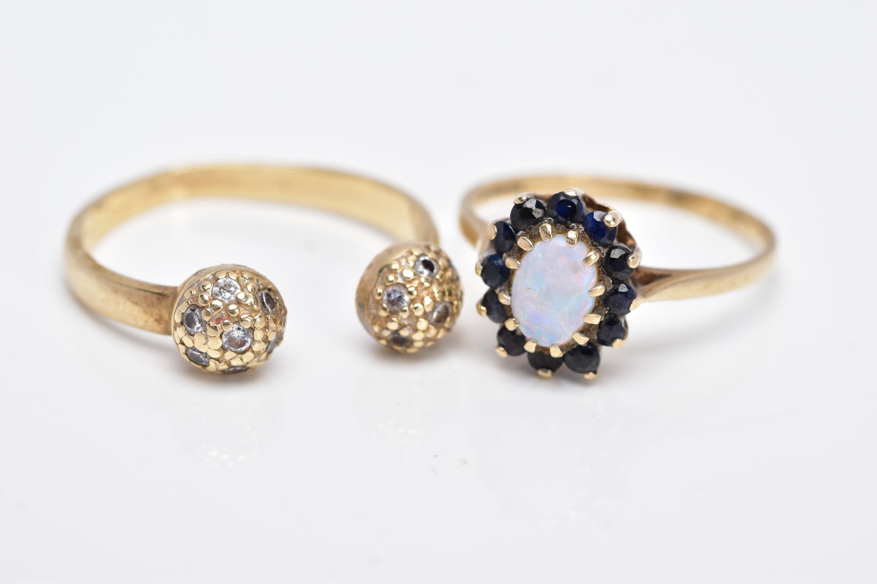 TWO 9CT GOLD RINGS, the first of a cluster design, centering on an oval cut opal cabochon, within