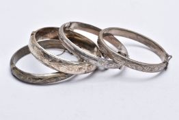 FOUR SILVER BANGLES, each decorated with an engraved foliate and scroll design, fitted with a push