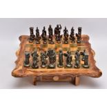 A SCRATCH BUILT WOODEN CHESS BOARD ON LEGS, two drawers to hold chess pieces, together with cast