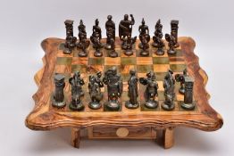 A SCRATCH BUILT WOODEN CHESS BOARD ON LEGS, two drawers to hold chess pieces, together with cast