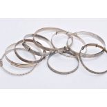 NINE SILVER AND WHITE METAL BANGLES, to include two silver foliate engraved bangles, each with a