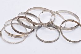 NINE SILVER AND WHITE METAL BANGLES, to include two silver foliate engraved bangles, each with a