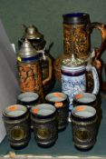 A GROUP OF RELIEF MOULDED STONEWARE BEER STEINS, etc, comprising a pewter covered jug with six