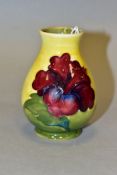A MOORCROFT SQUAT BALUSTER VASE DECORATED WITH TWO DARK RED HIBISCUS, on a yellow and green