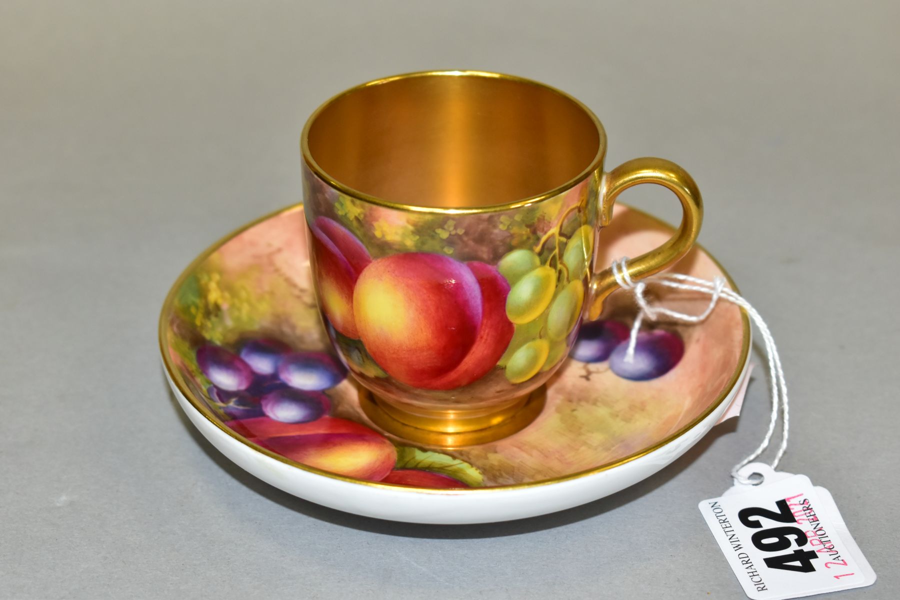 A ROYAL WORCESTER PORCELAIN CABINET FRUIT STUDY COFFEE CUP AND SEPARATE SAUCER, both decorated