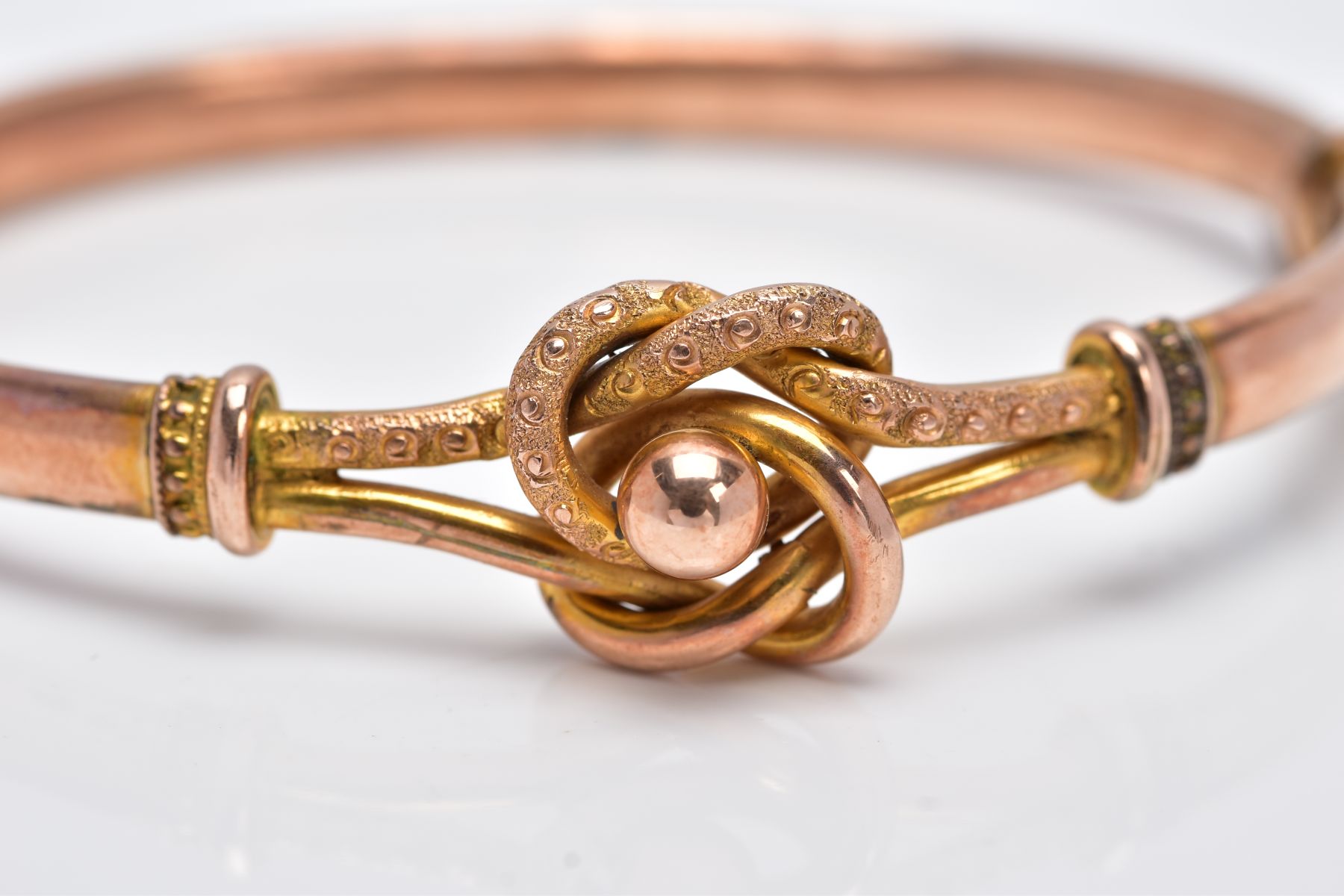A YELLOW METAL BANGLE, the hinged bangle of a knot and ball openwork design, fitted with a push - Image 4 of 4
