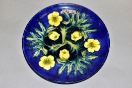 A LIMITED EDITION MOORCROFT 1990 YEAR PLATE, decorated with buttercups on a blue ground, no 42/