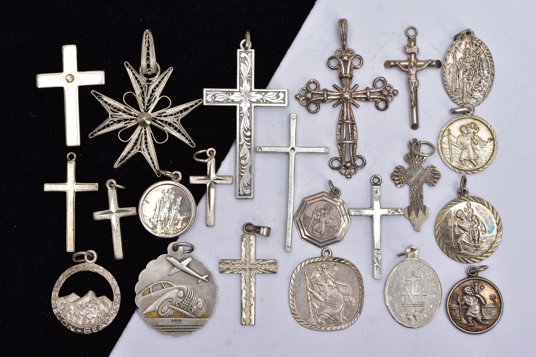 A BAG OF ASSORTED SILVER AND WHITE METAL PENDANTS, to include two silver crosses with hallmarks
