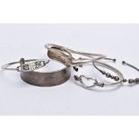 A BAG OF ASSORTED SILVER AND WHITE METAL BANGLES, the first silver bangle in the form of two