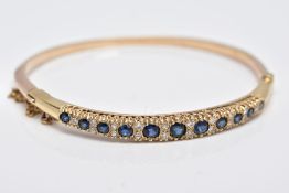 A 9CT GOLD SAPPHIRE AND DIAMOND HALF HOOP GRADUATED BANGLE, sapphires graduating from 3.0mm-4.5mm in