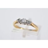 A YELLOW METAL THREE STONE RING, designed with two round brilliant cut diamonds and a single cut