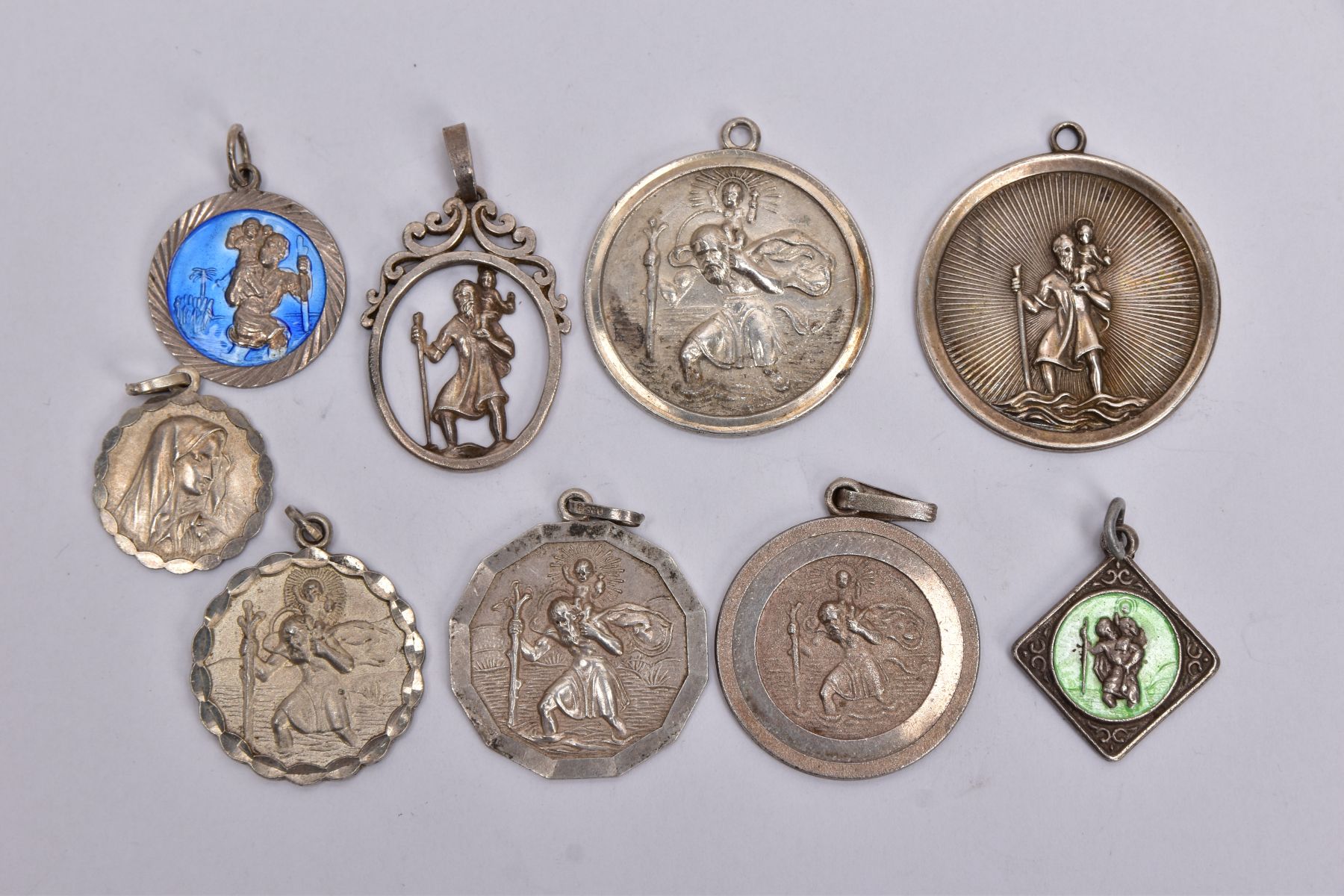 NINE SILVER AND WHITE METAL ST CHRISTOPHER PENDANTS, to include two circular pendants one fitted